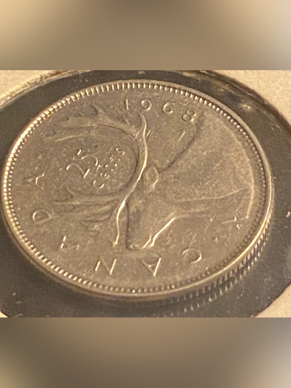 1968 Canadian 25-cent coin featuring a caribou design on the reverse.